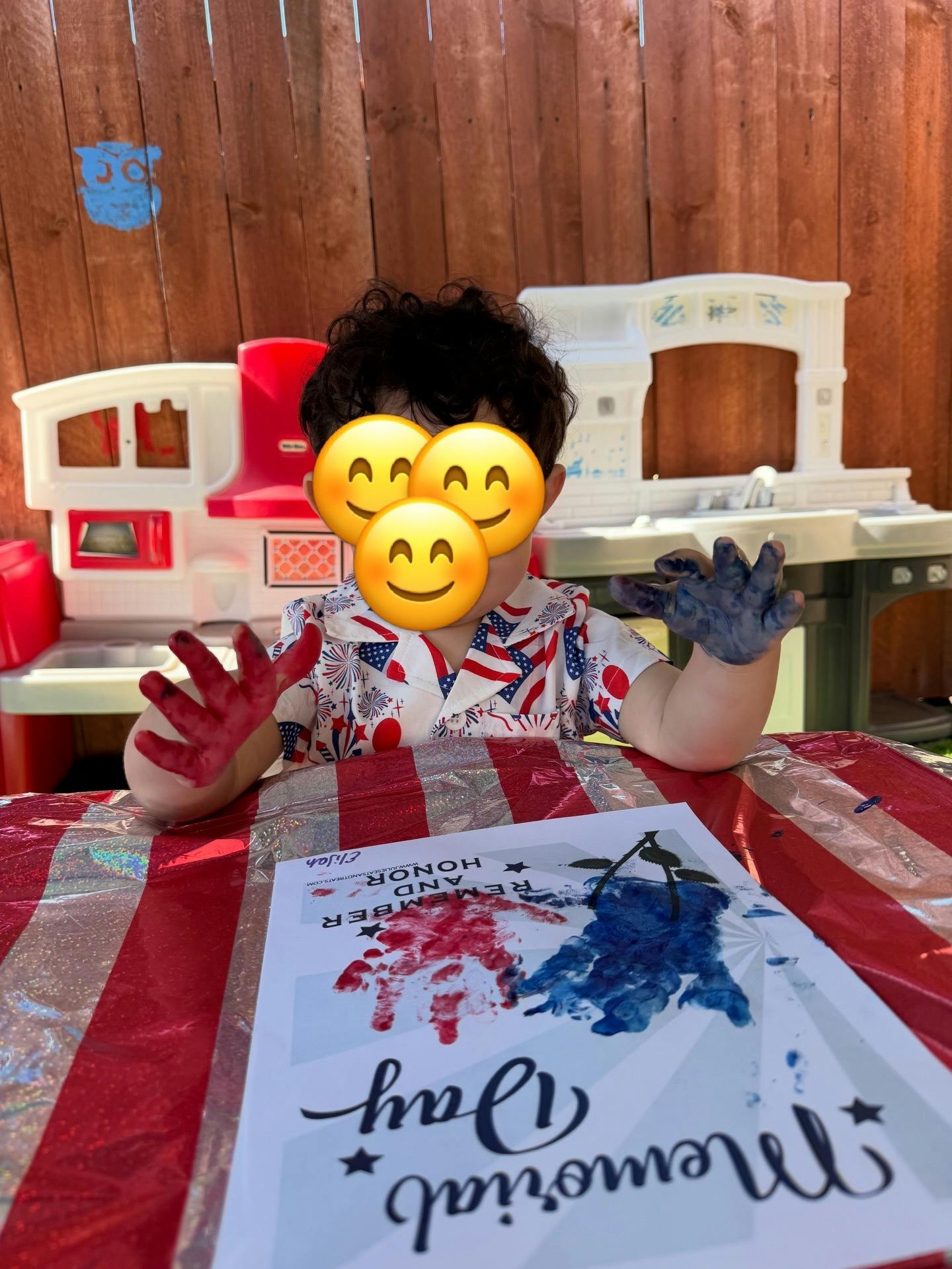 Child with red and blue paint on their hands making a handprint craft