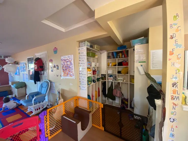Child on playmat in a room with a rocking chair and storage shelves