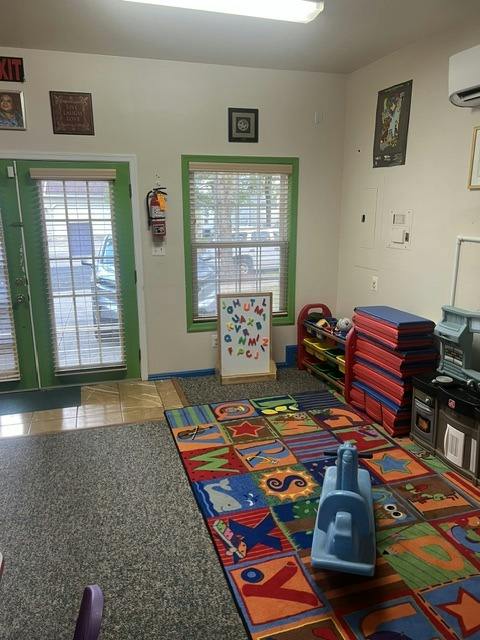 Playroom with children's rug, toys, and a magnetic letter board