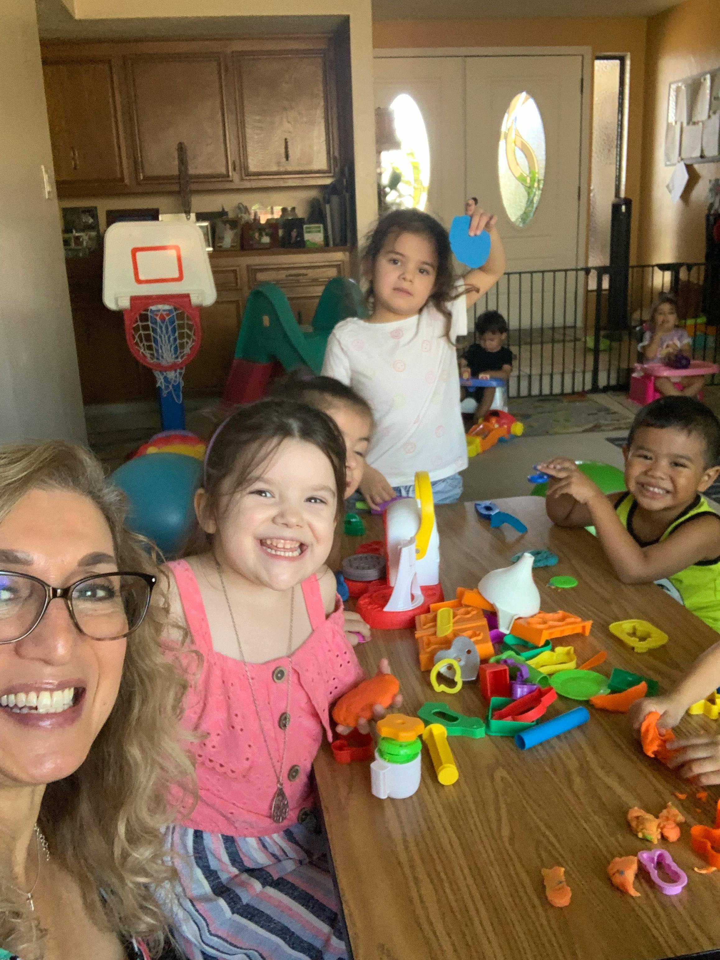 Adult and children playing with toys at a table