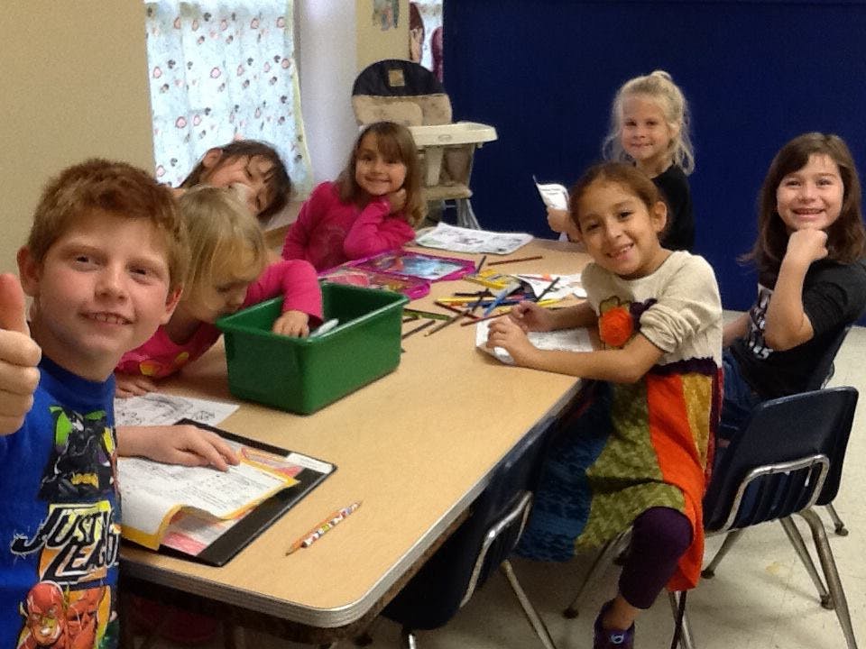 Children sitting at a table in a classroom