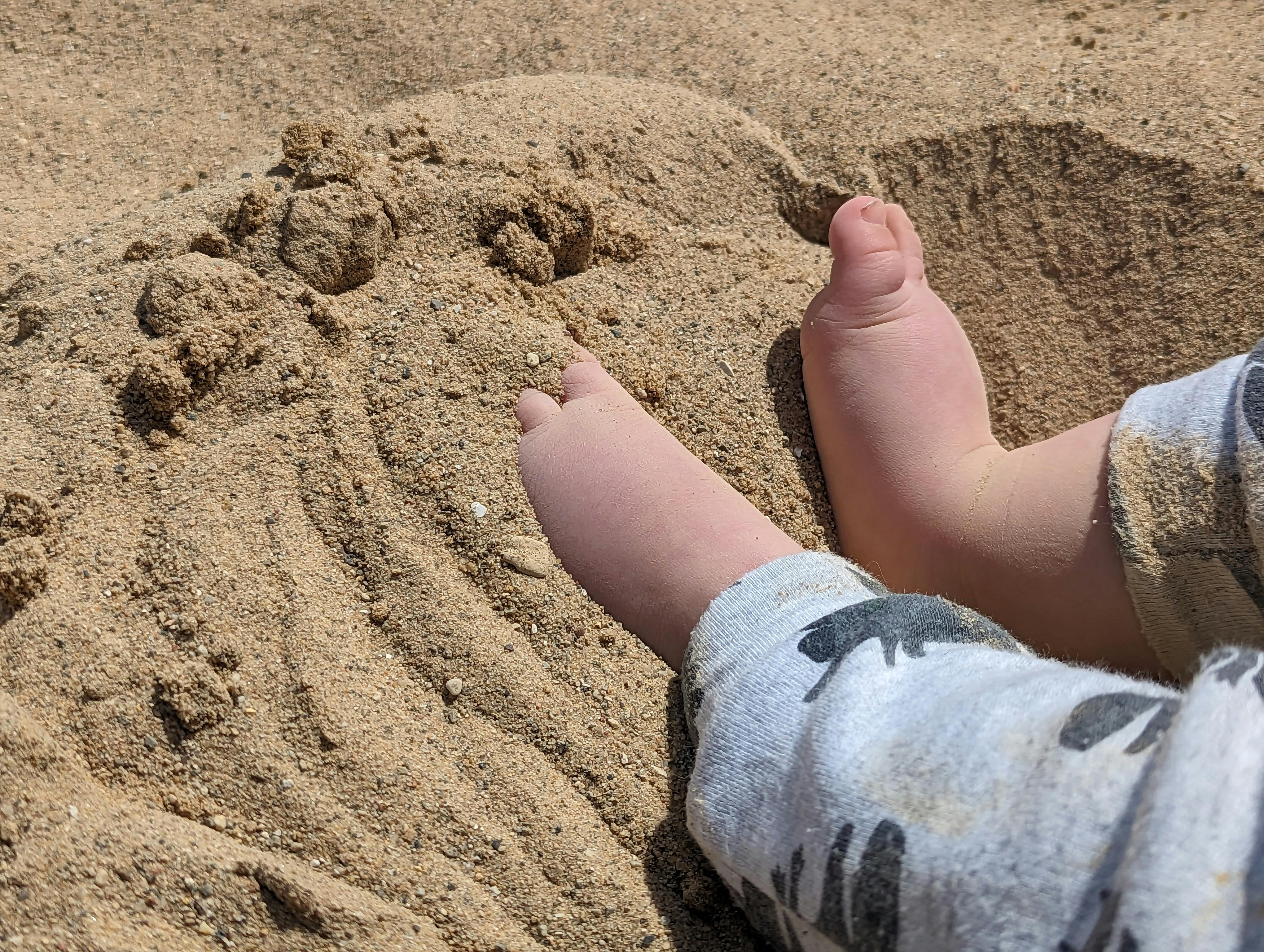 Child's feet and legs in sand