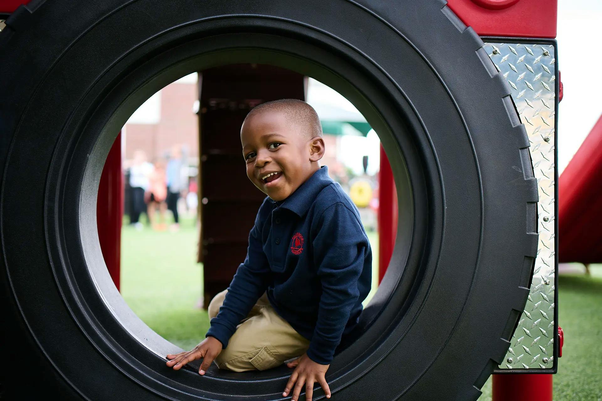 Child sitting inside a large tire on a playground