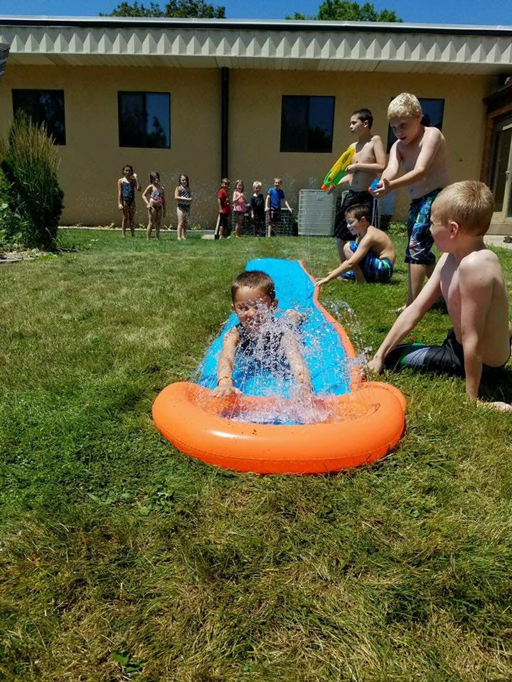 Child playing in a small inflatable pool with water splashing