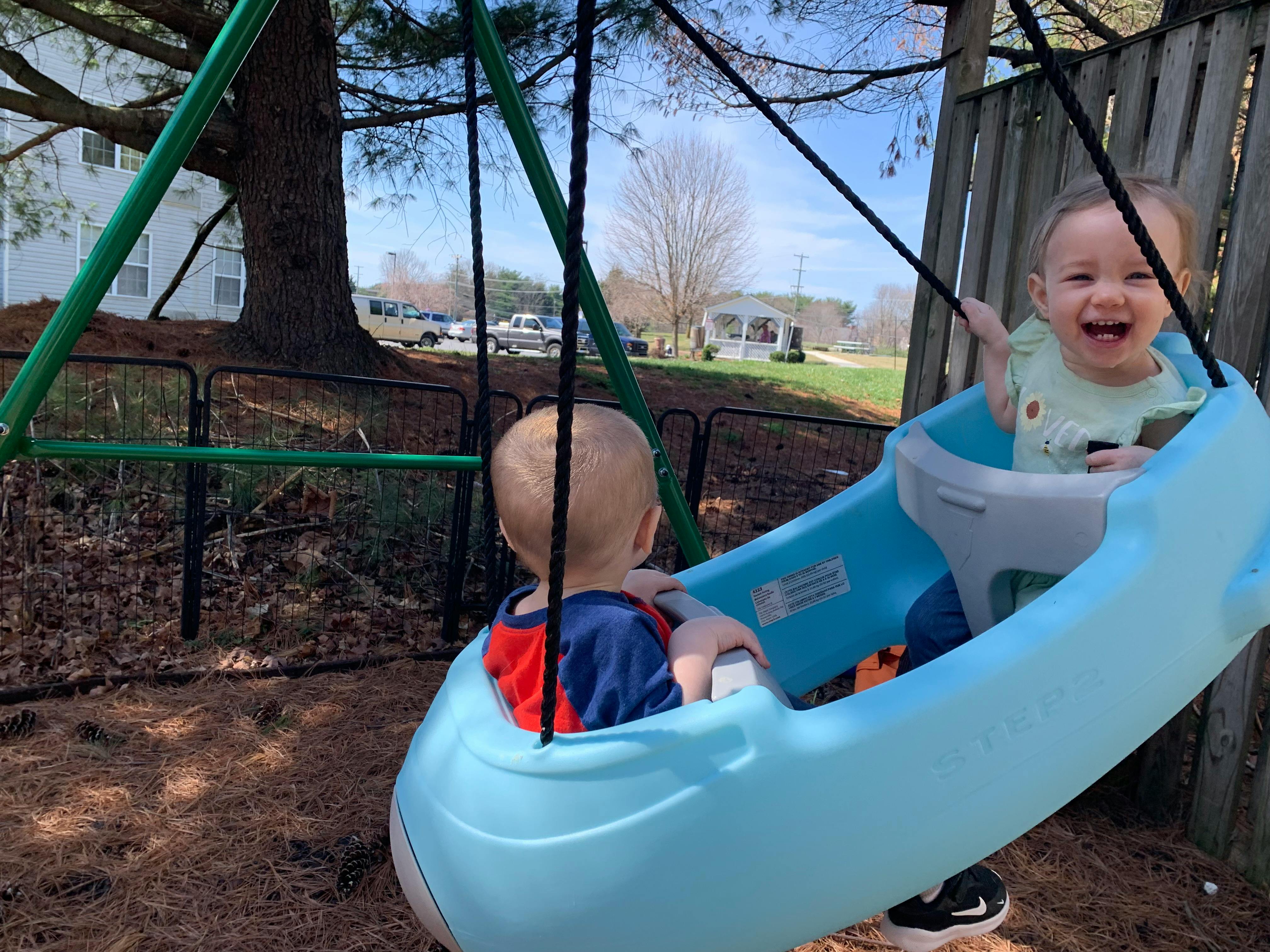 Two children in swings on a playground