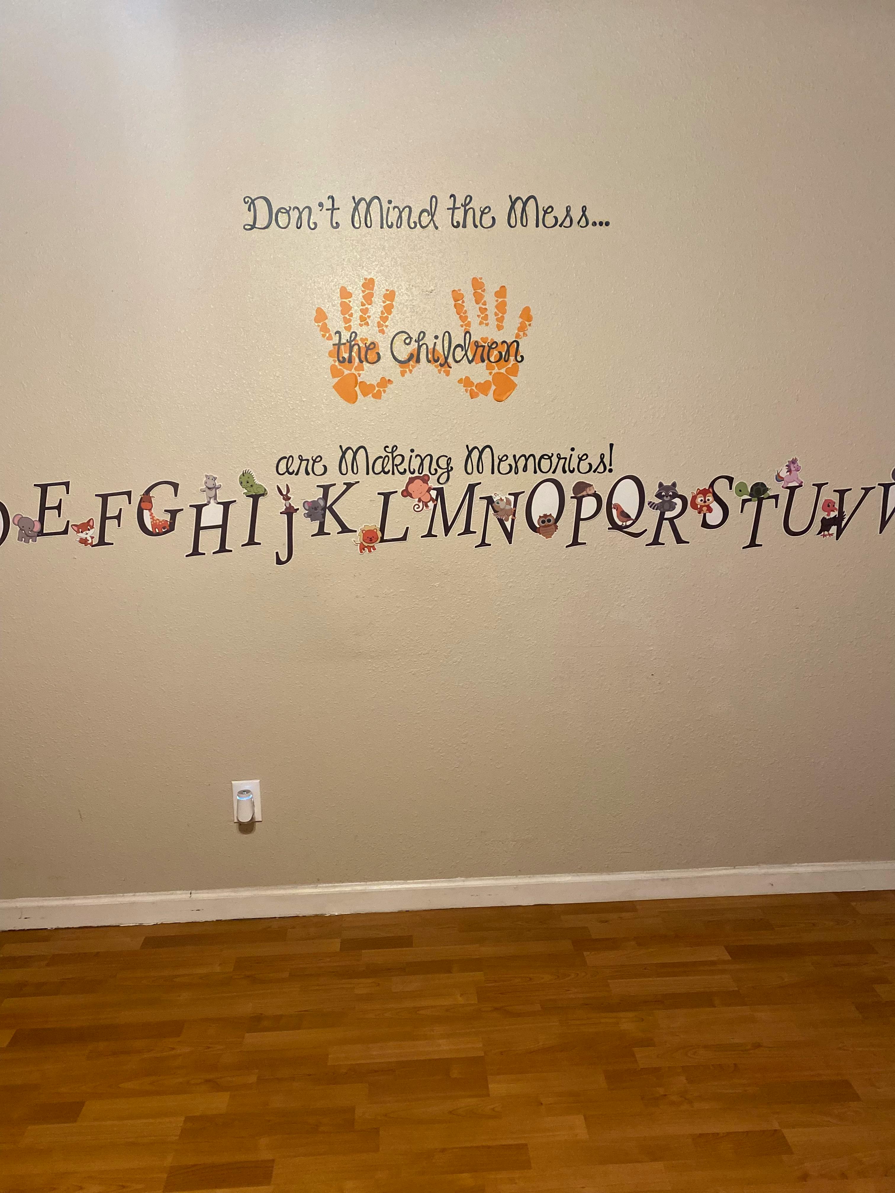 Wall with text "Don't Mind the Mess... the Children are Making Memories!" and alphabet
