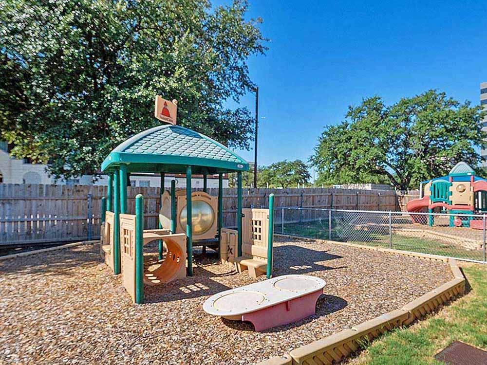Playground area with wood chips and various play structures