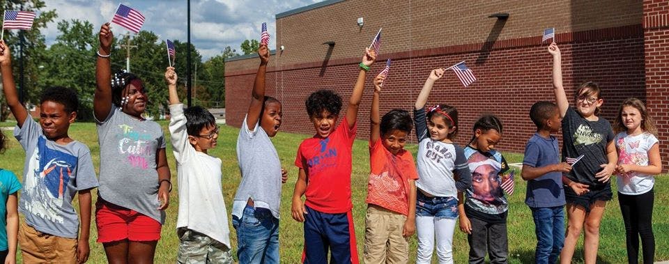 Group of children holding small American flags