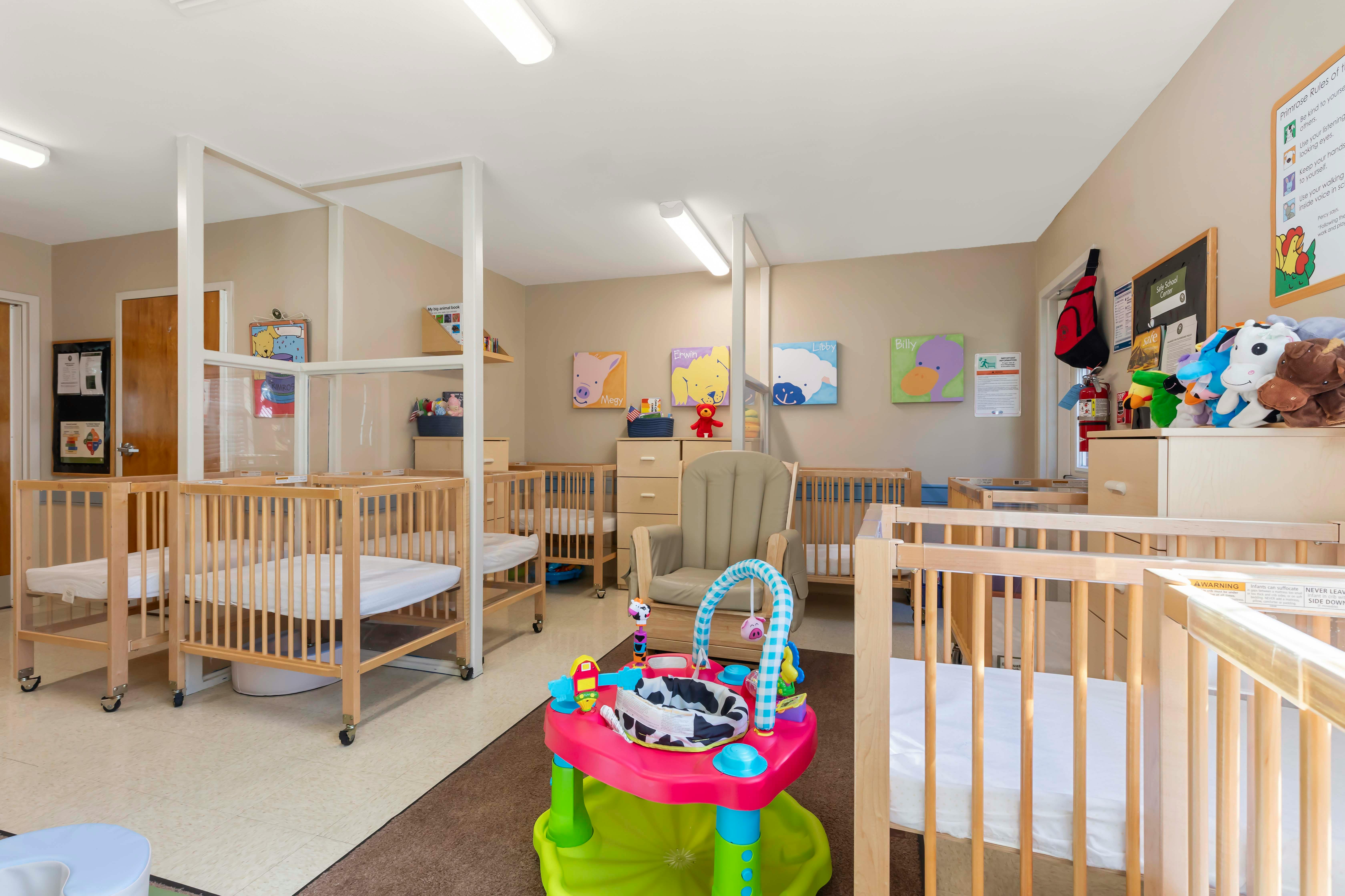 Cribs and child activity center in a daycare room