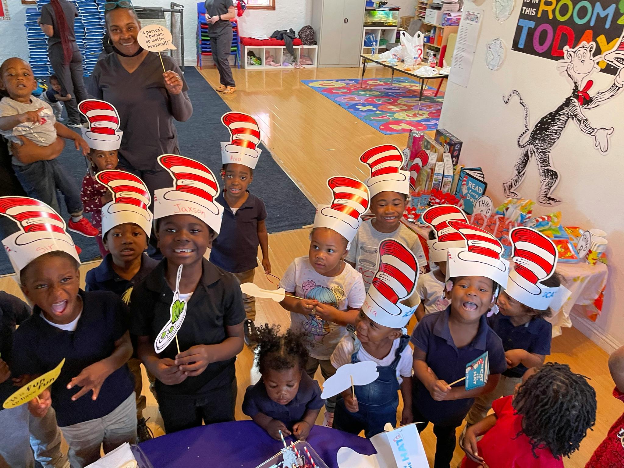 Group of children wearing red and white striped hats in a classroom