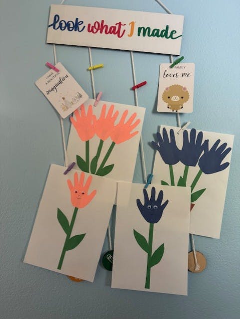 Child's art display with handprint flowers and text "look what I made"