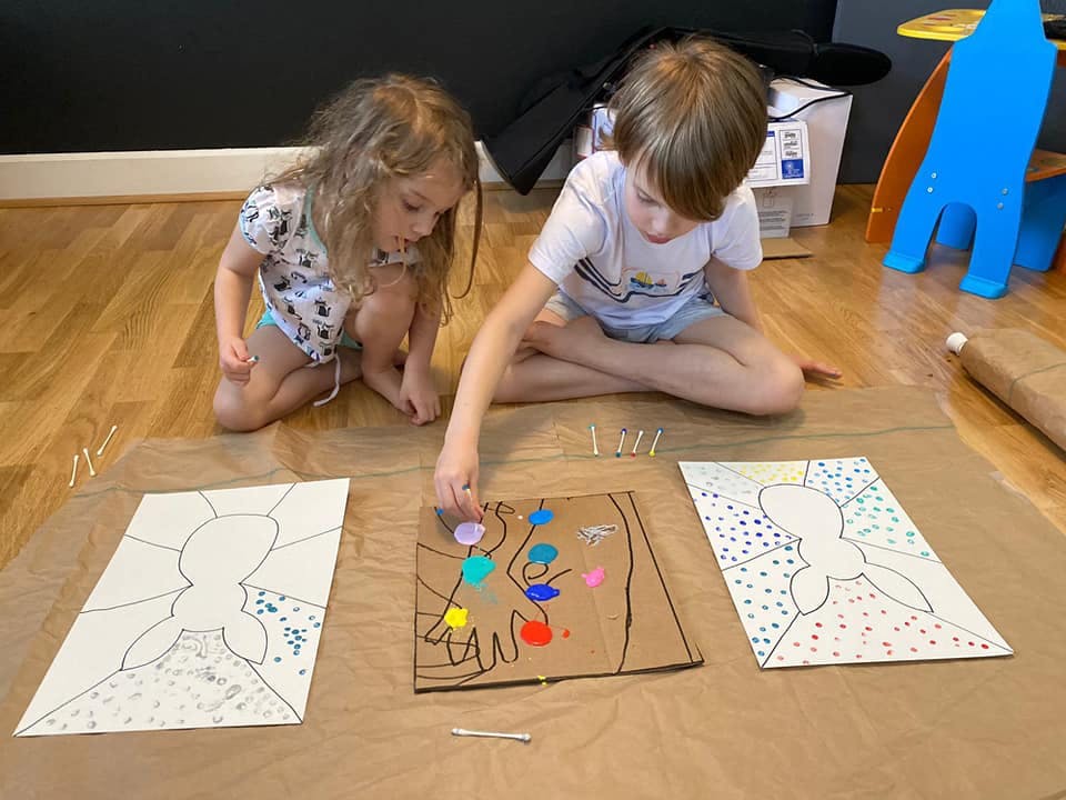 Two children painting on the floor