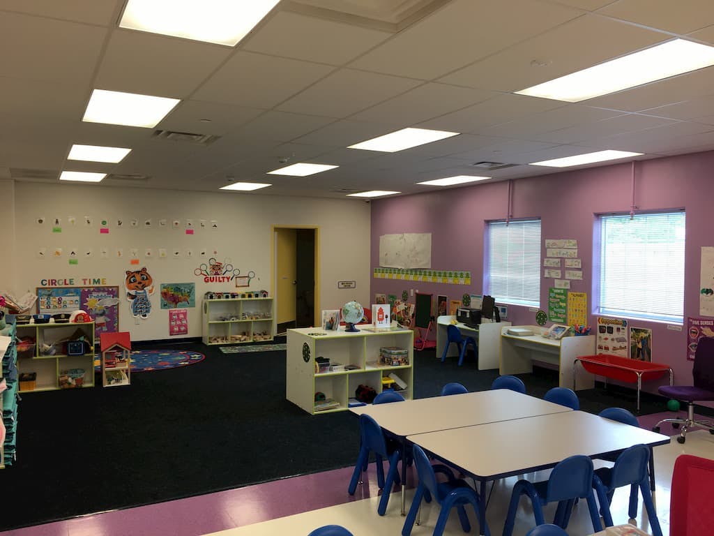 Empty classroom with tables, chairs, and shelves
