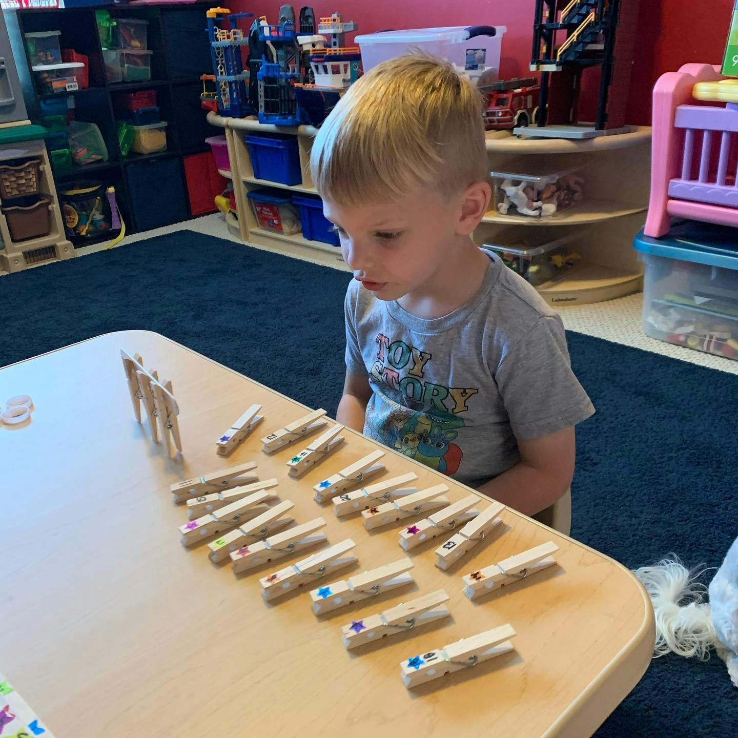 Child at a table with clothespins