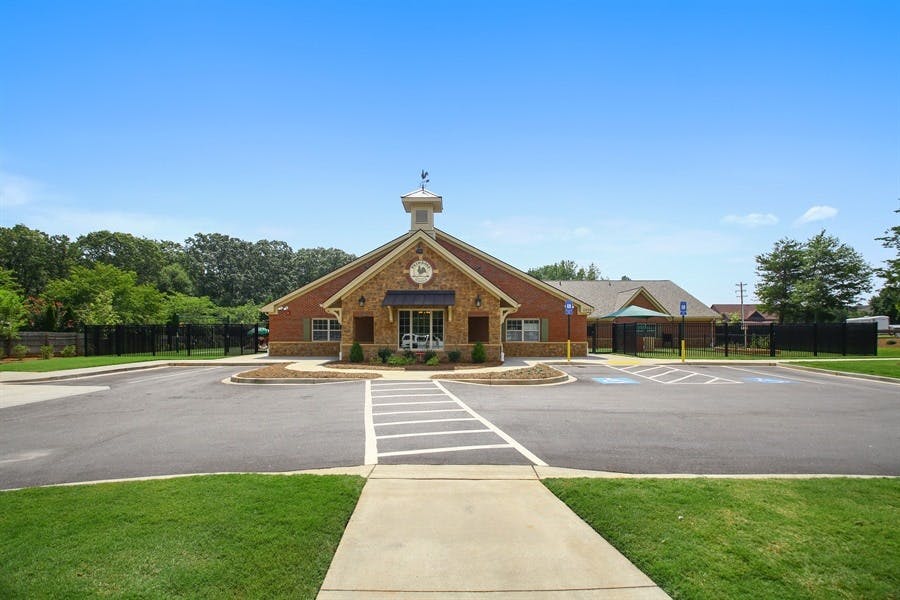 Building with a steeple and a parking lot in front