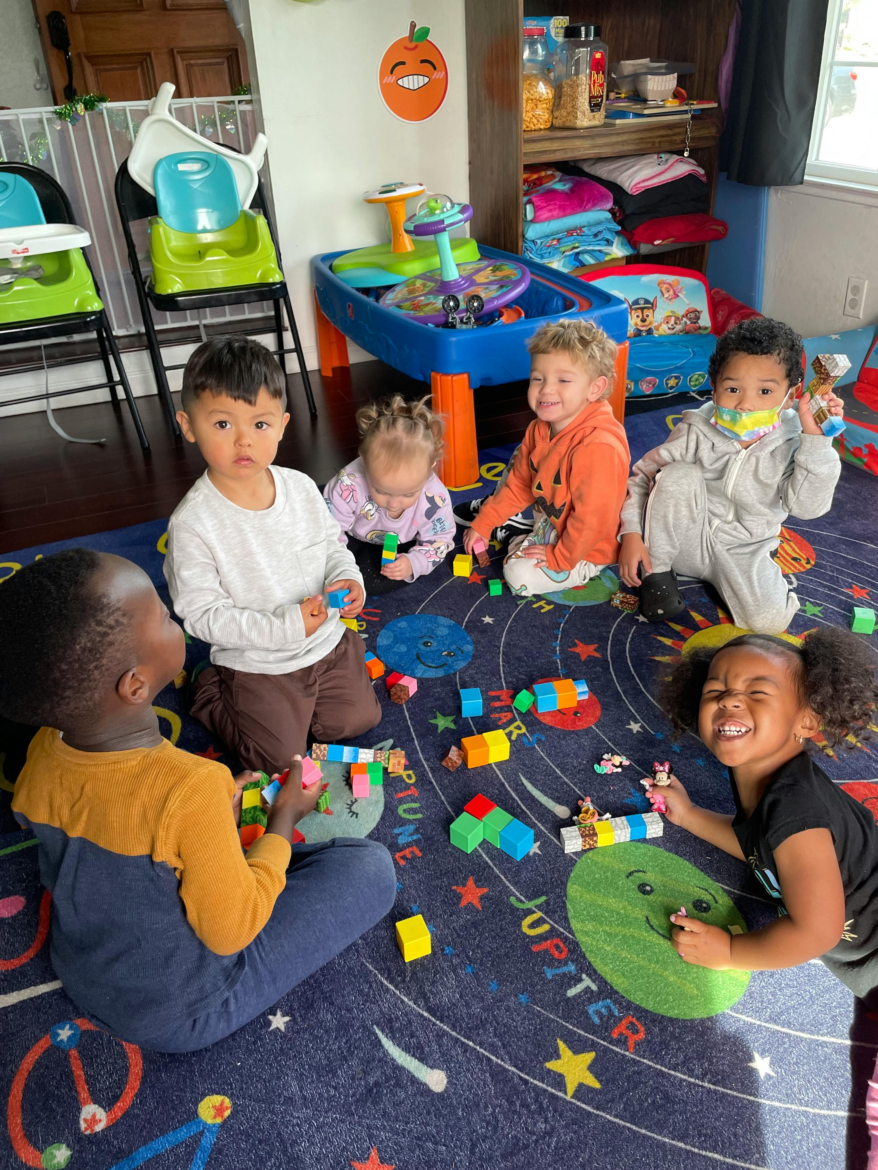 Children playing with blocks on a rug