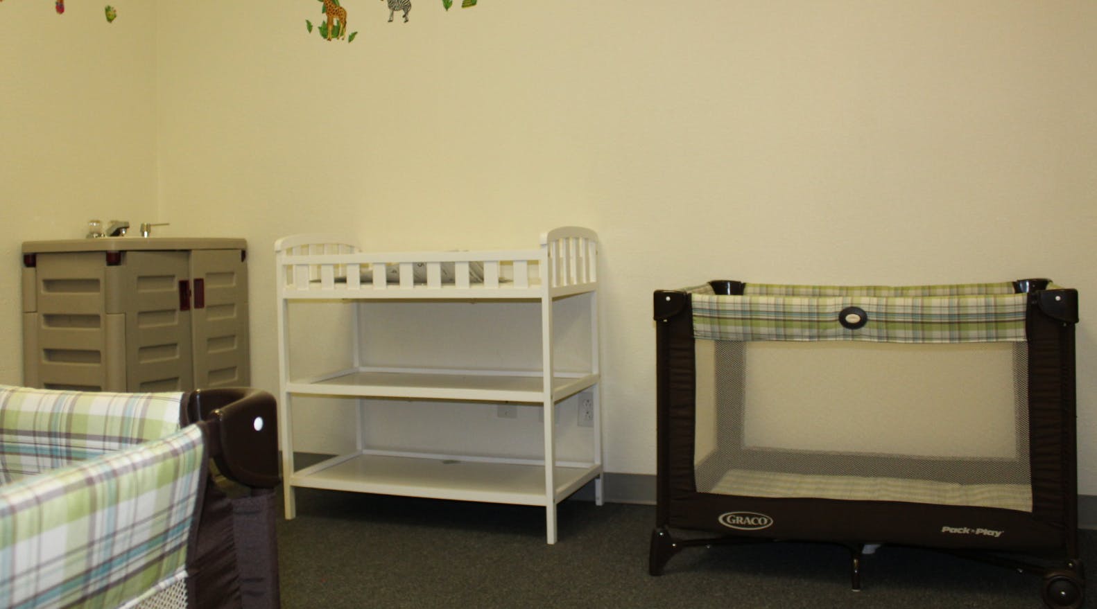 Nursery room with a changing table, crib, and playpen