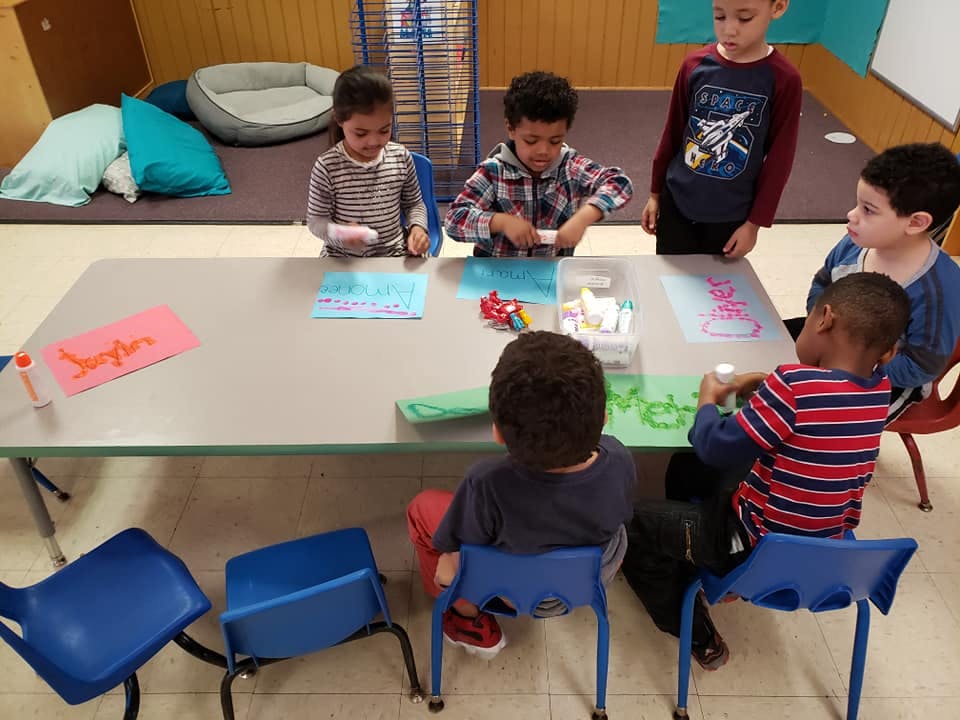 Children sitting at a table doing an activity
