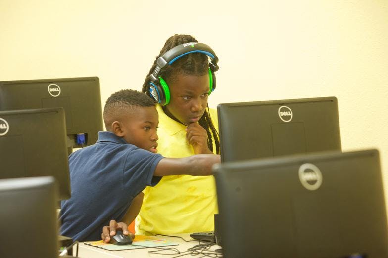 Two children looking at a computer screen in a classroom