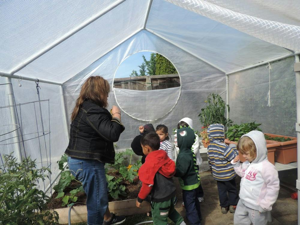 Person and children in a greenhouse