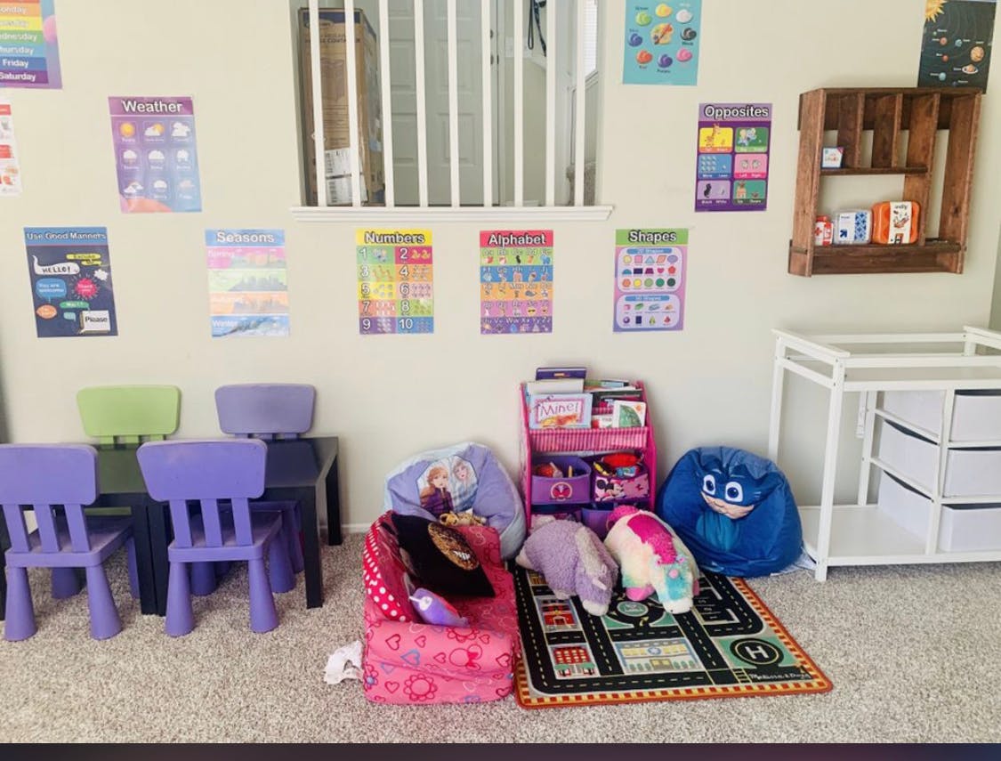 Children's play area with small chairs, tables, and colorful posters on the wall