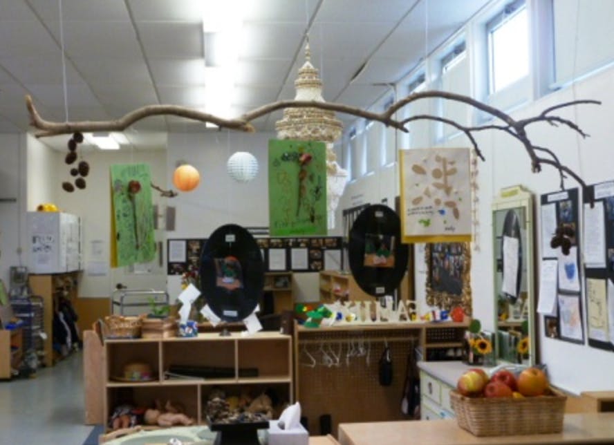Classroom with natural decor including branches, hanging lanterns, and artwork