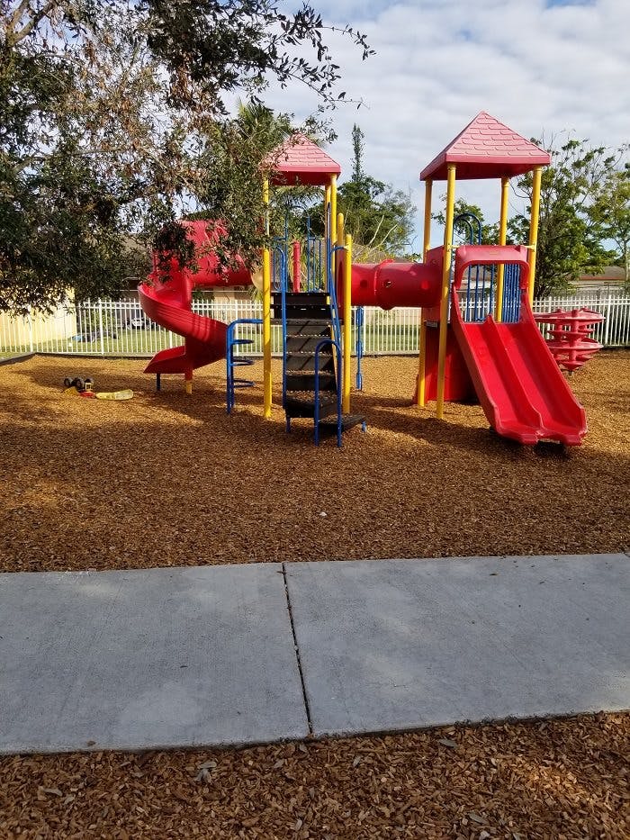 Playground with red slides and yellow and blue climbing structures