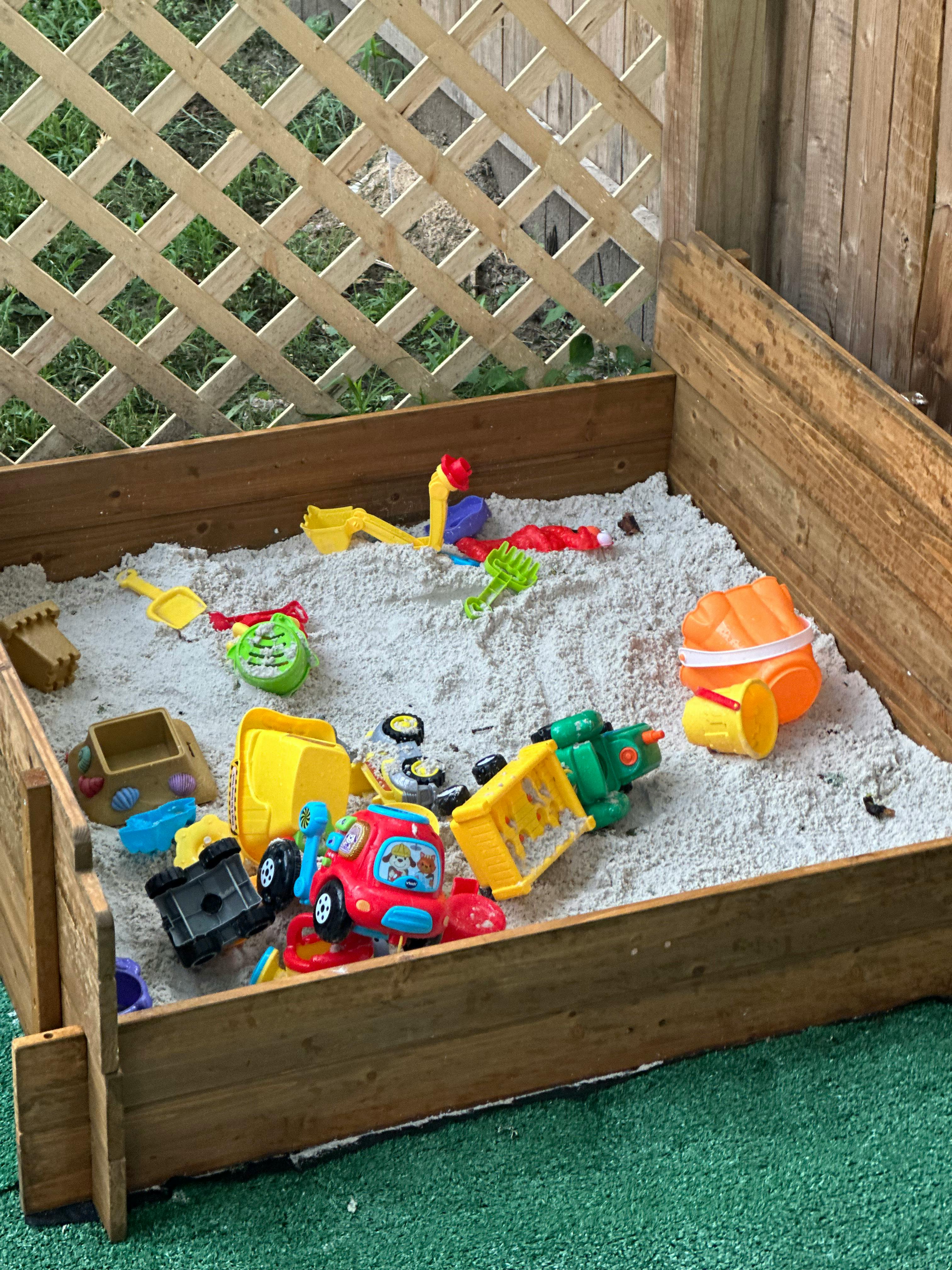 Sandbox with various colorful plastic toys