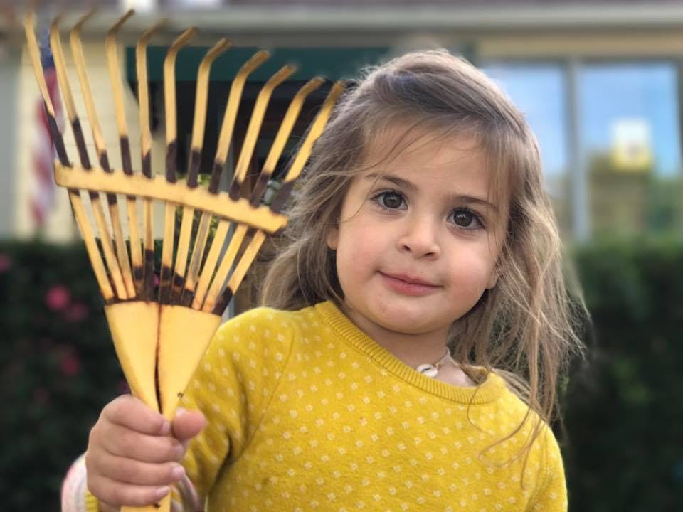 Child holding a rake