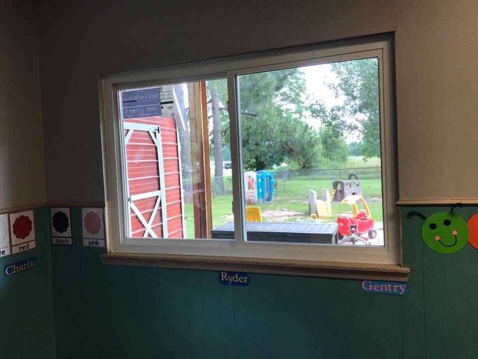 Window looking out onto a red shed and a playground