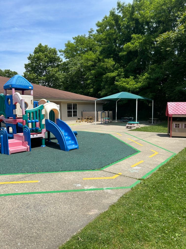 Outdoor playground with a slide structure and a small playhouse
