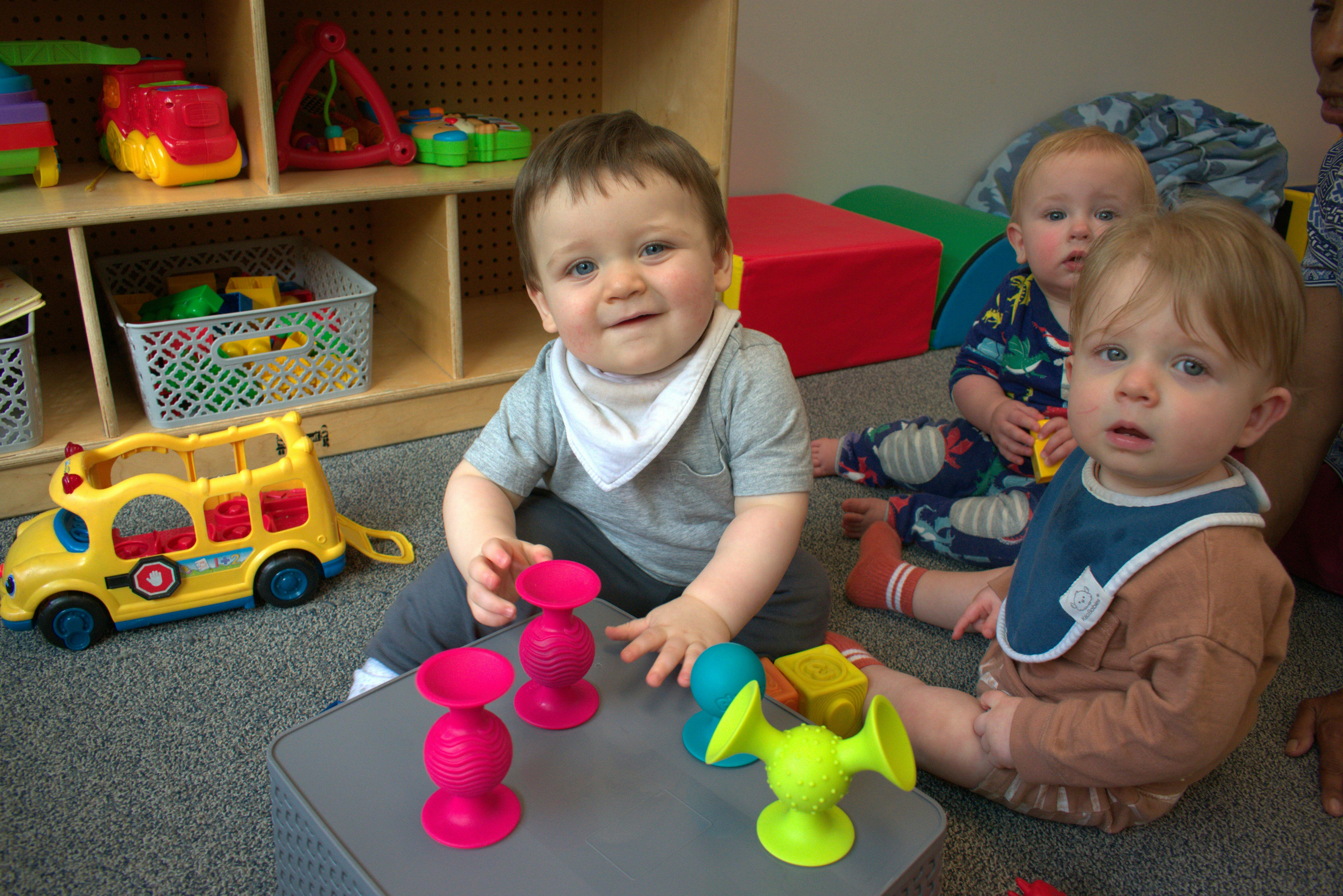 Three children playing with toys on the floor
