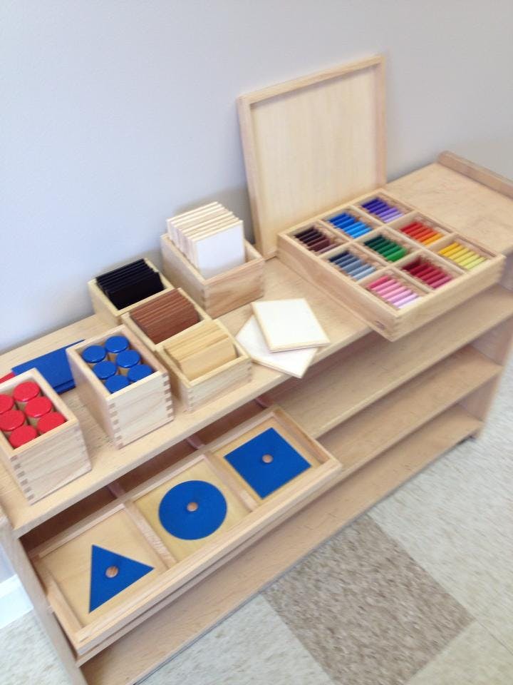 Montessori classroom materials on a wooden shelf