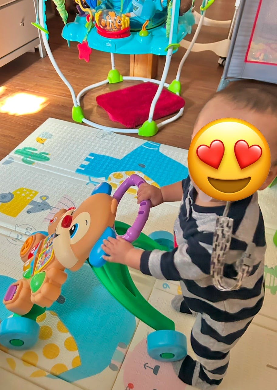 Child standing and holding a toy walker