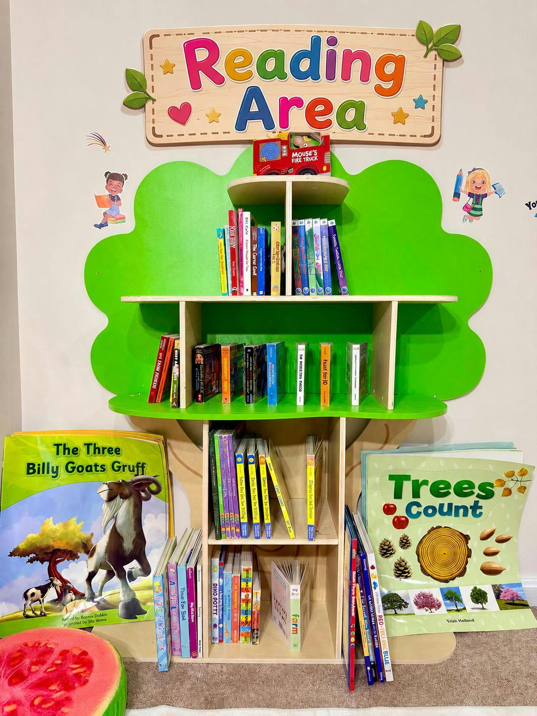 Children's book display shelf with books and a "Reading Area" sign above it