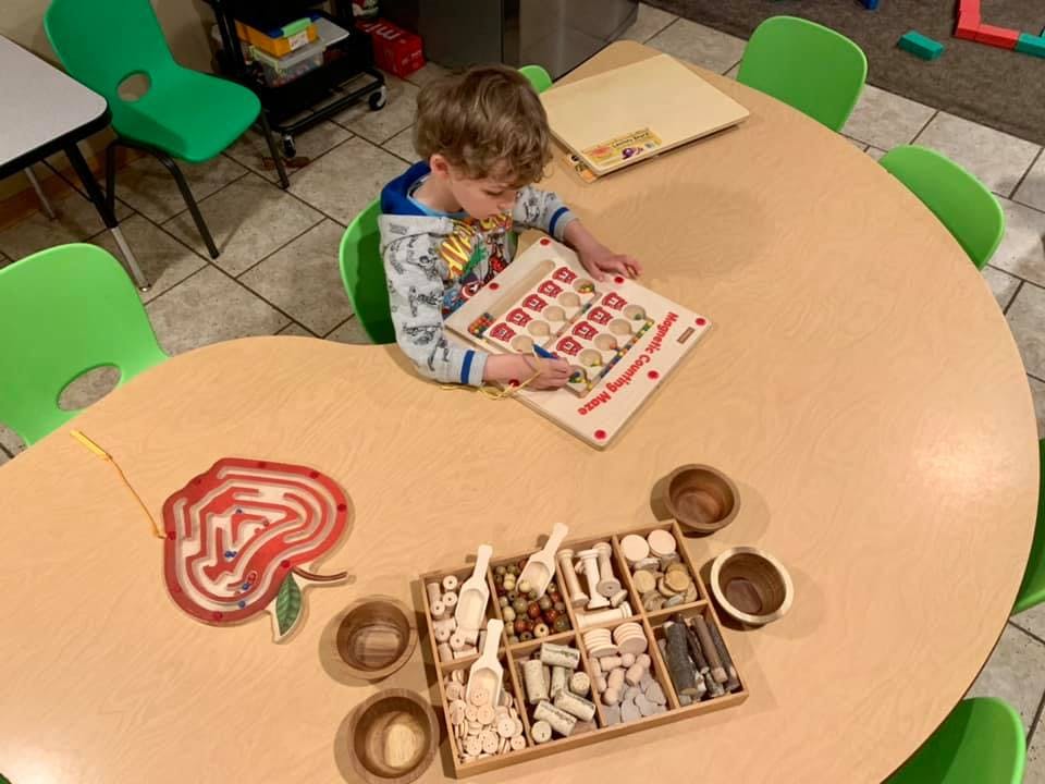 Child playing with a learning board at a table
