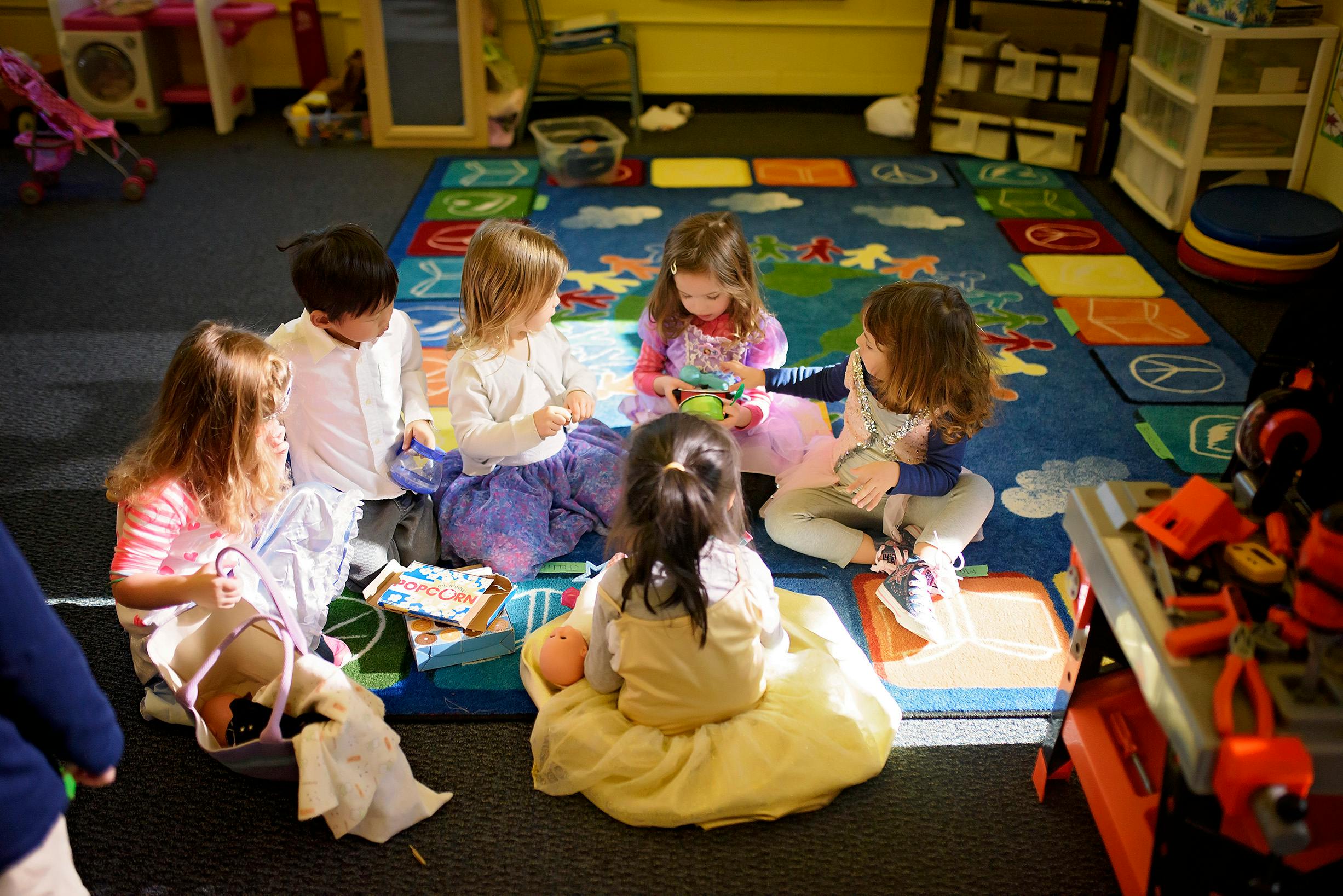 Group of children sitting on a rug in a classroom