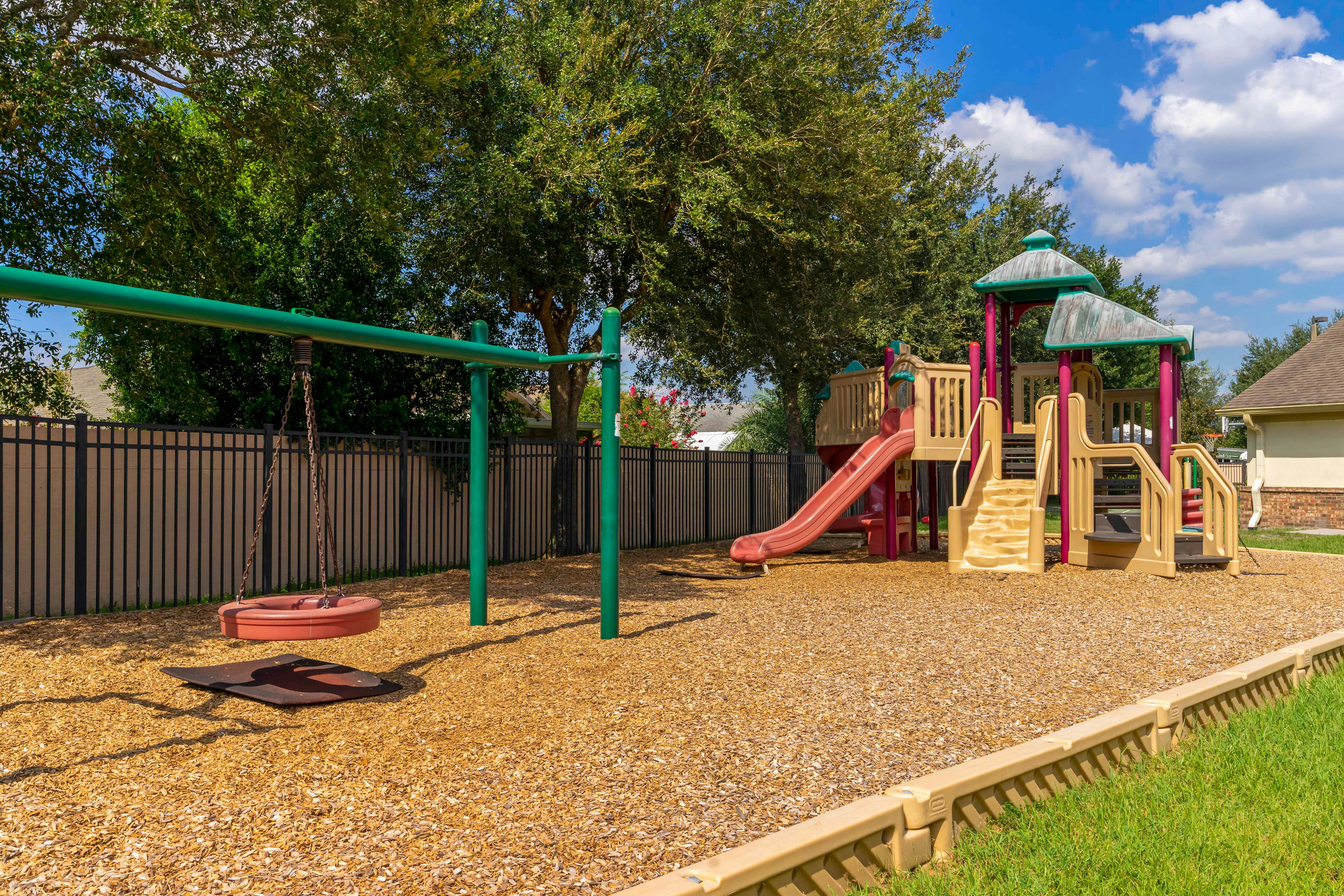 A colorful playground with a tire swing, slides, and climbing structures