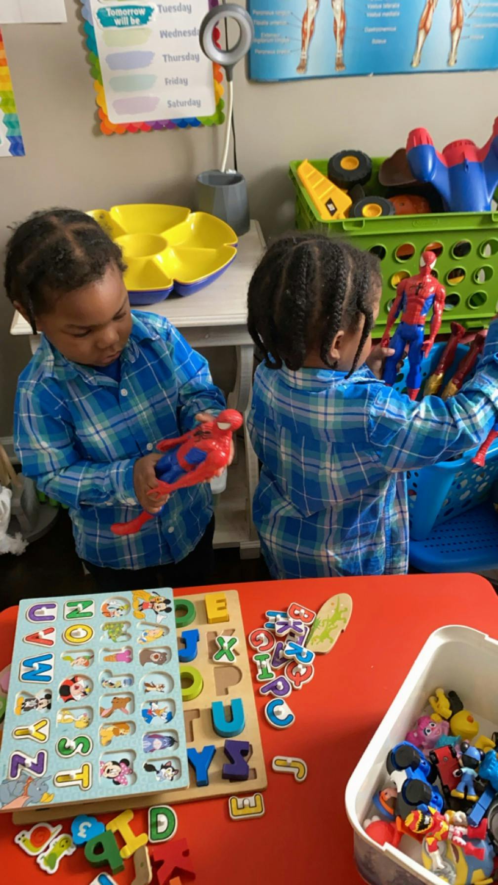 Two children playing with toys, one holding a Spider-Man figure