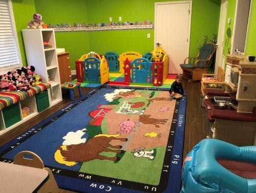 Child playing on a farm-themed rug in a playroom