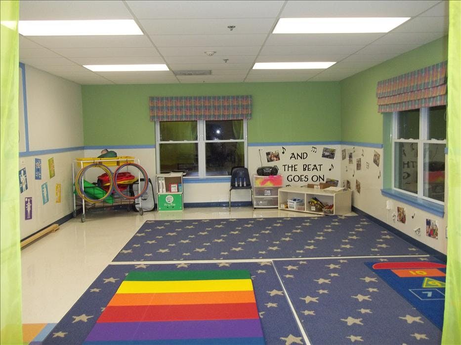 Classroom with green walls, star-patterned carpet, and hula hoops