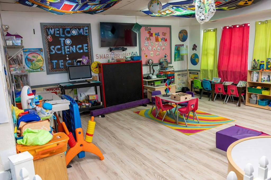 Classroom decorated with science theme posters and child-sized tables