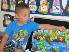 Child playing with a frog-themed learning activity