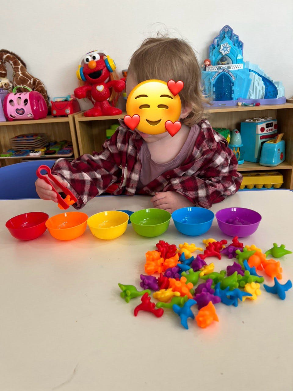 Child sorting colorful animal-shaped counters into bowls