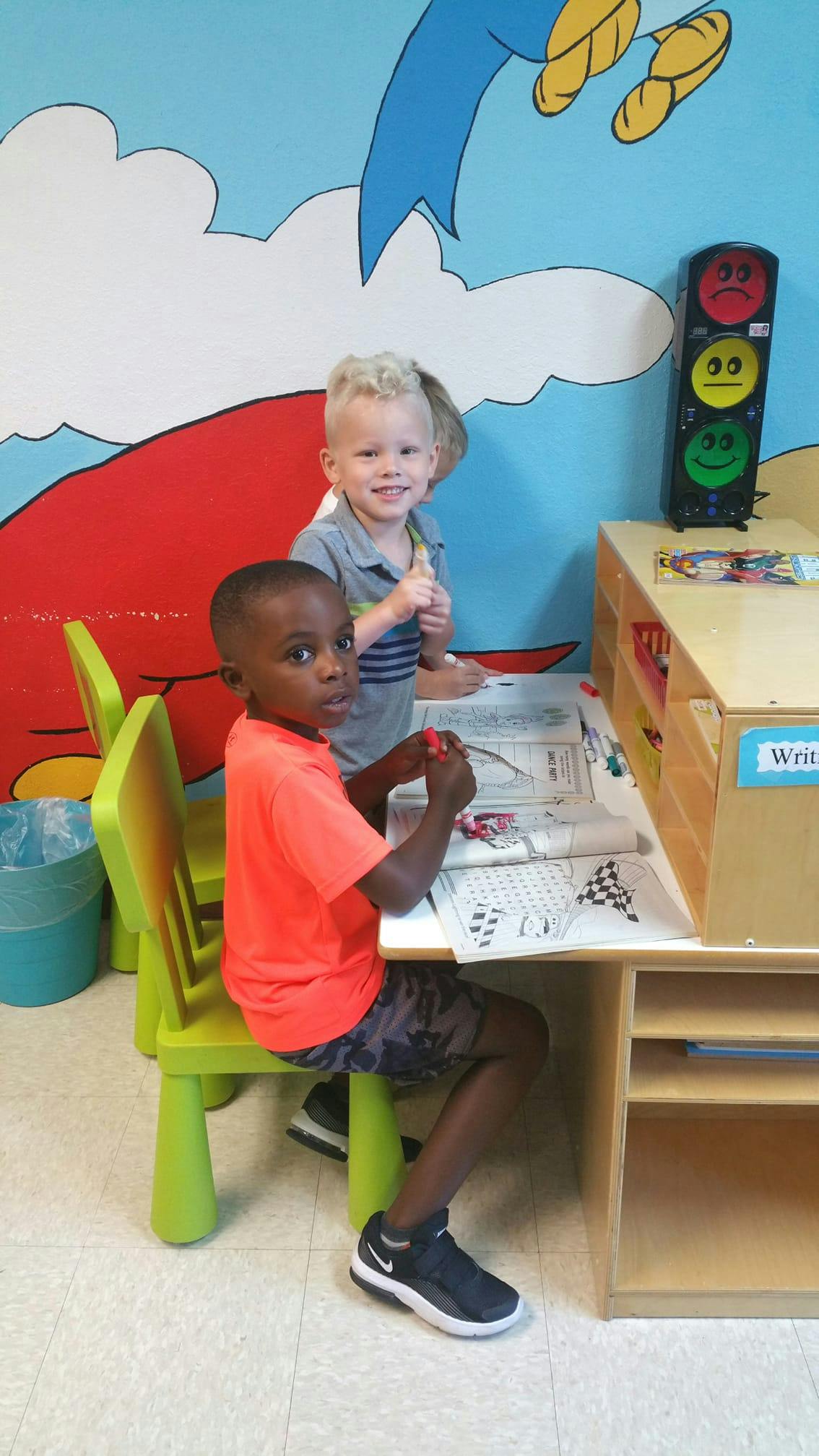 Two children at a desk in a classroom