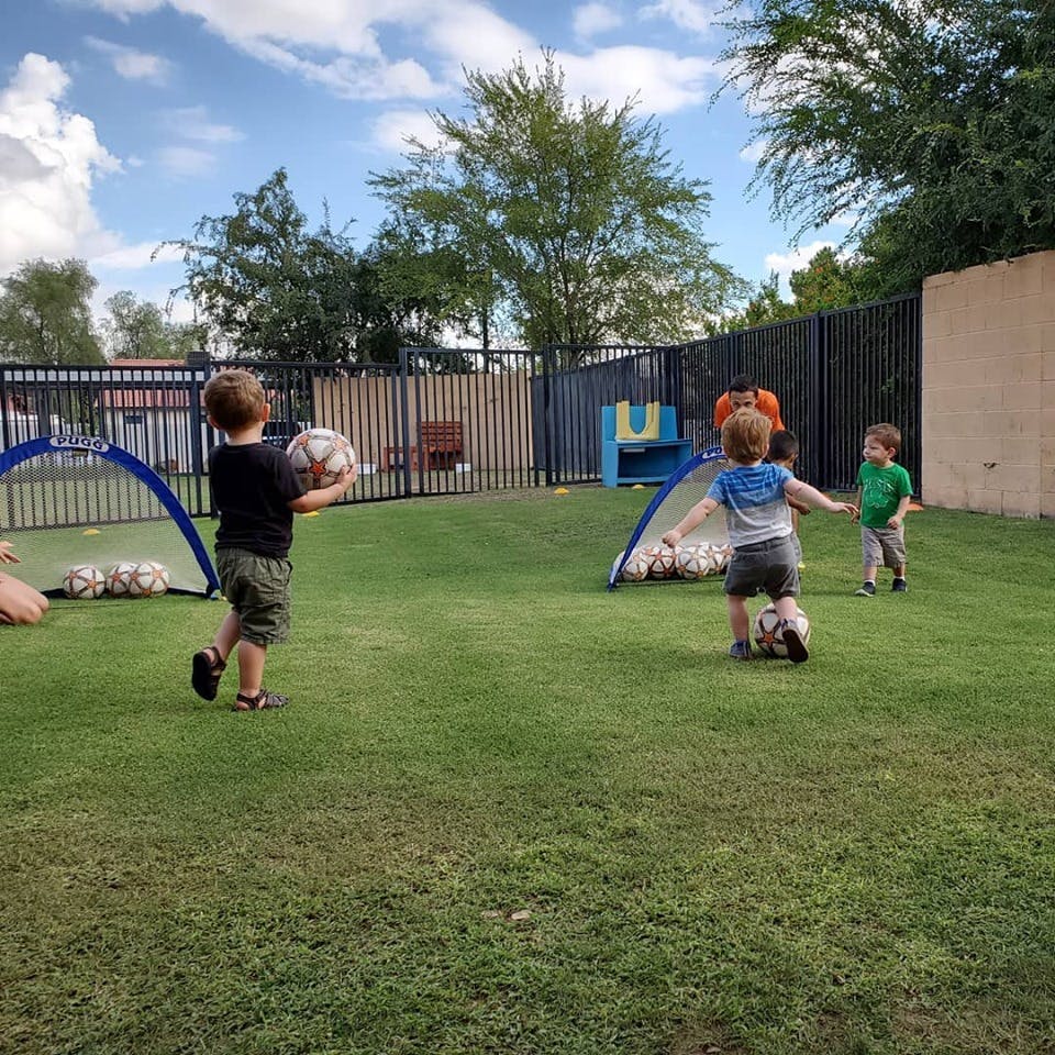 Children playing soccer on a grassy field