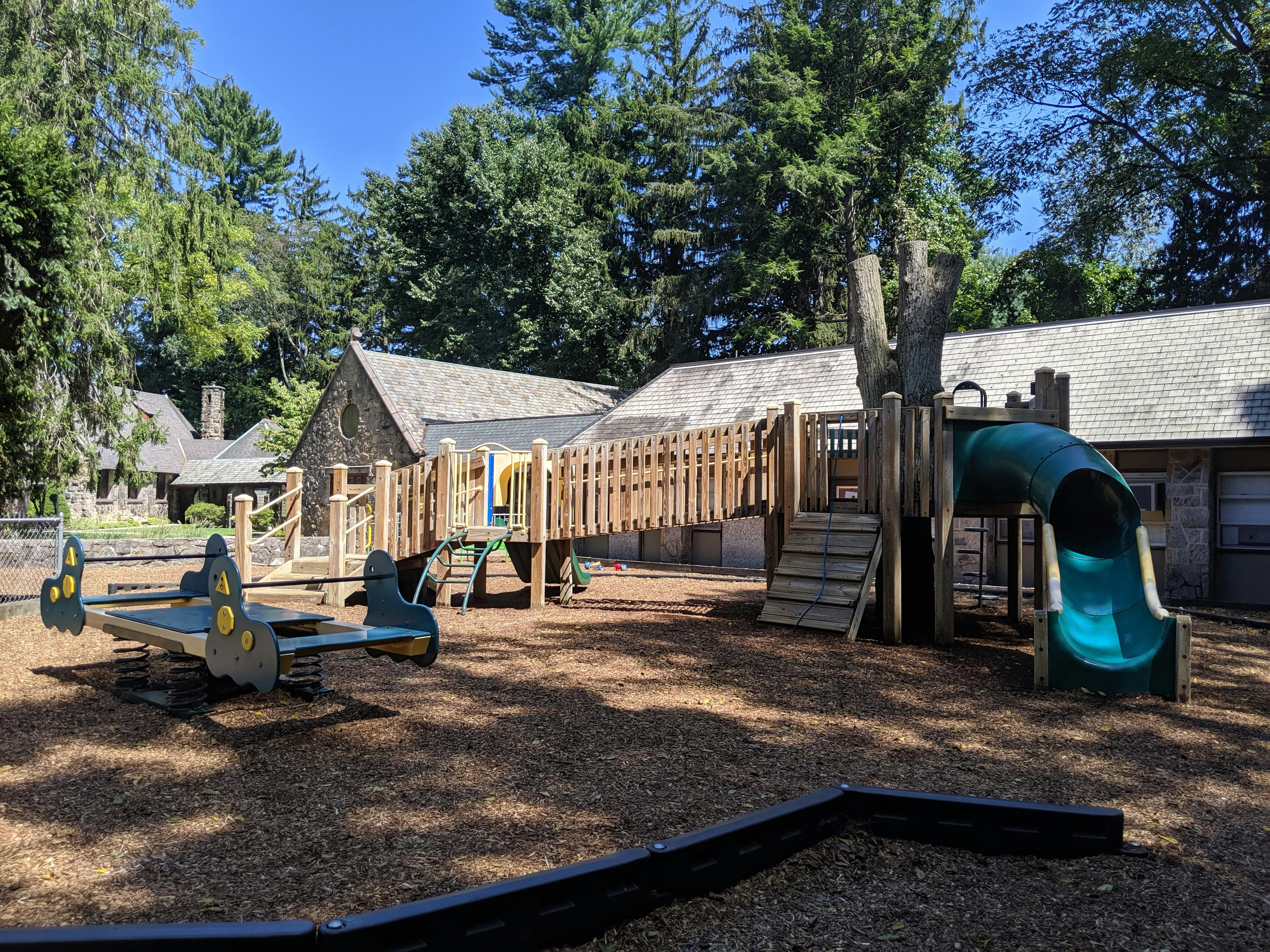 Playground with a wooden structure, slide, and seesaw