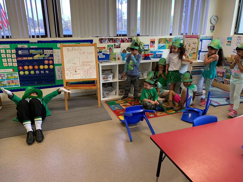 Children in green hats in a classroom
