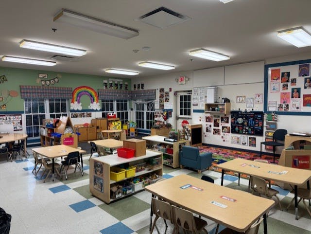 Empty colorful children's classroom with small tables and chairs