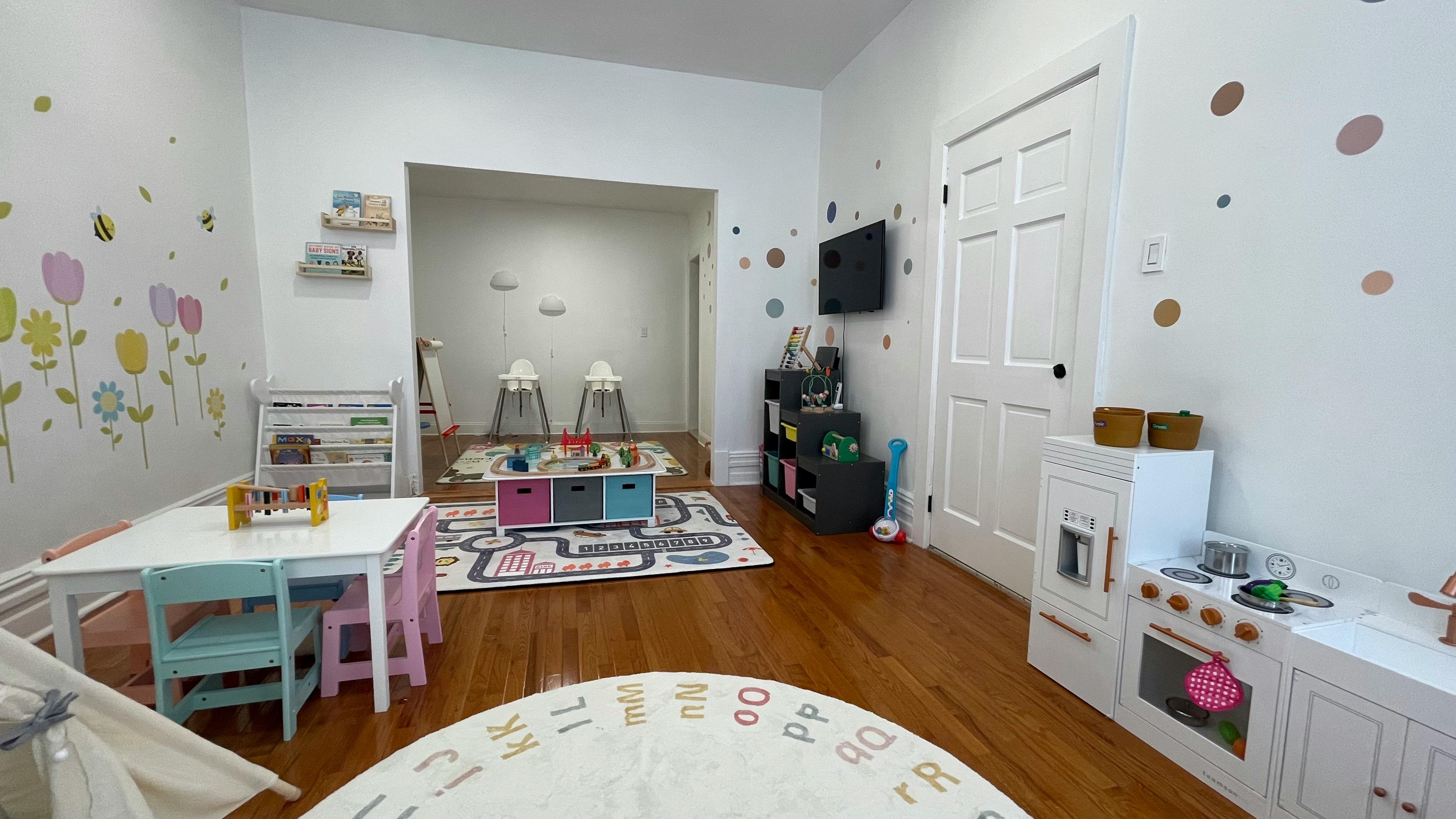 Playroom with small tables, chairs, and toy kitchen